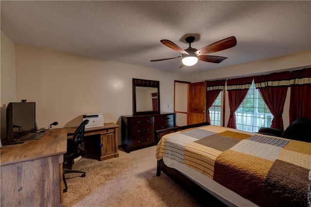 carpeted bedroom featuring access to outside, a textured ceiling, and ceiling fan