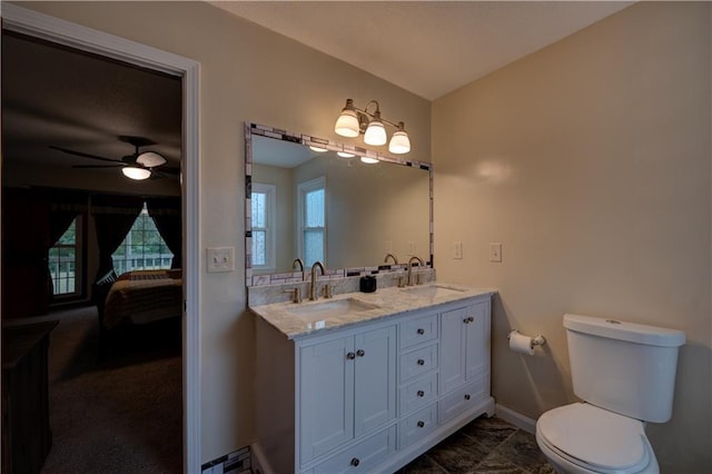 bathroom with toilet, vanity, and ceiling fan