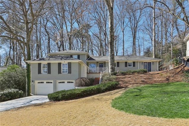 view of front of home with brick siding, concrete driveway, a front lawn, and a garage