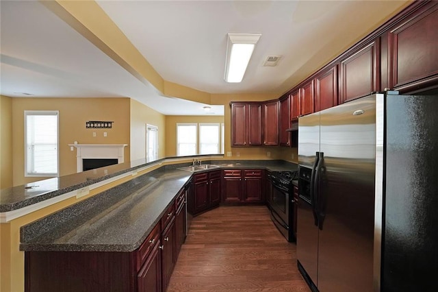 kitchen with appliances with stainless steel finishes, kitchen peninsula, sink, and a wealth of natural light