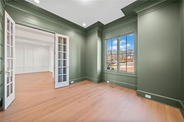 unfurnished room featuring french doors, baseboards, and wood finished floors