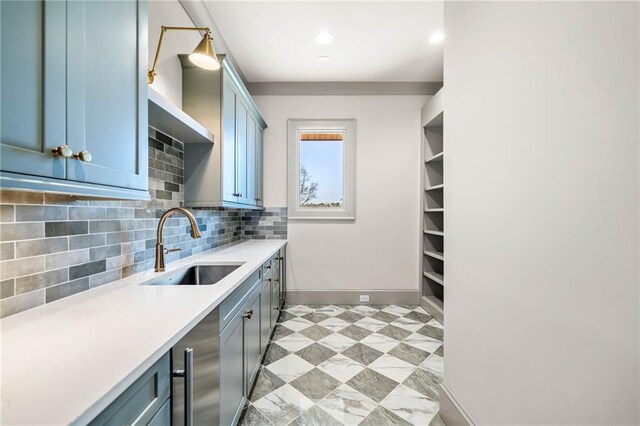 kitchen featuring light countertops, tasteful backsplash, recessed lighting, baseboards, and a sink