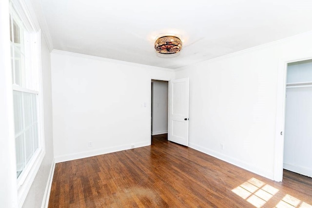 unfurnished bedroom with baseboards, ornamental molding, and wood finished floors