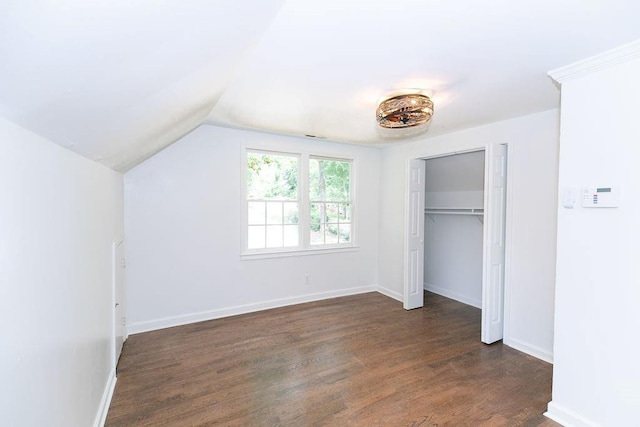 unfurnished bedroom with baseboards, a closet, dark wood-style floors, and lofted ceiling