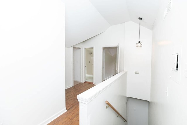 corridor featuring an upstairs landing, light wood finished floors, and lofted ceiling