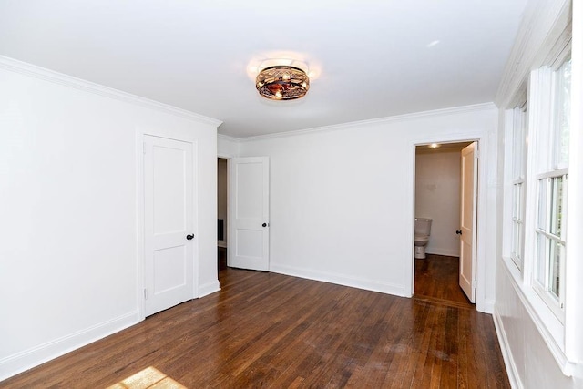spare room featuring dark wood-style flooring, baseboards, and ornamental molding