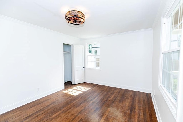unfurnished bedroom with baseboards, dark wood finished floors, ornamental molding, and a closet