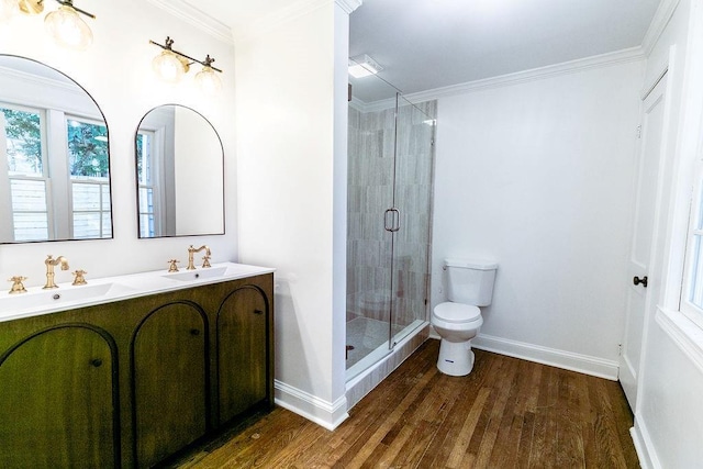 bathroom with a stall shower, toilet, a sink, and wood finished floors