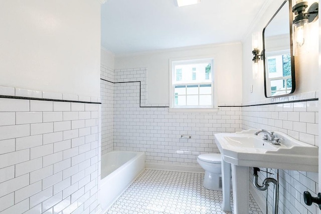 bathroom featuring crown molding, a bathing tub, toilet, and tile walls