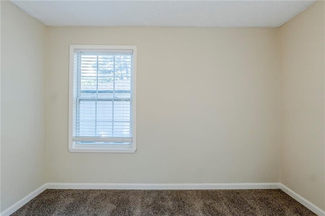 unfurnished room with baseboards and carpet flooring