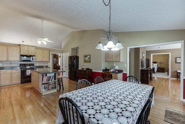 dining room with lofted ceiling, light wood-style flooring, a textured ceiling, and ceiling fan with notable chandelier