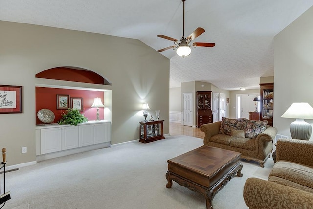 living room featuring a ceiling fan, vaulted ceiling, a textured ceiling, and light colored carpet