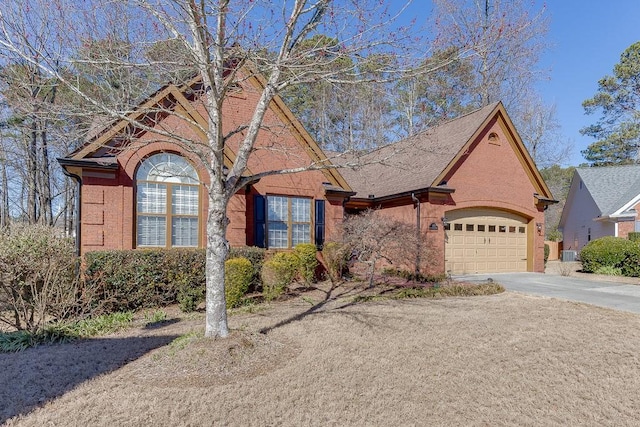 view of front of home featuring an attached garage, driveway, central AC unit, and brick siding