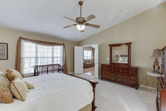 bedroom featuring baseboards, light colored carpet, ceiling fan, vaulted ceiling, and a textured ceiling