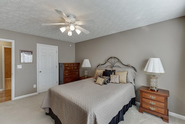 bedroom with a textured ceiling, baseboards, and light colored carpet