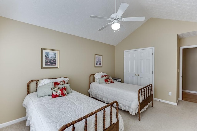 bedroom with ceiling fan, light colored carpet, baseboards, vaulted ceiling, and a closet