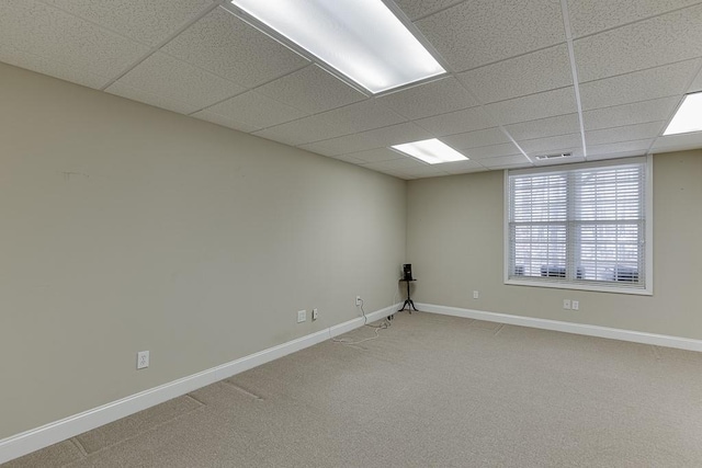 spare room with visible vents, carpet flooring, a paneled ceiling, and baseboards