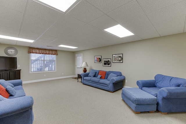 carpeted living area with a paneled ceiling and baseboards