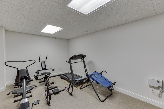 workout room with a paneled ceiling, baseboards, and carpet flooring