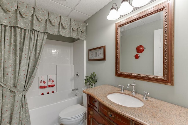 bathroom featuring shower / tub combo, a drop ceiling, vanity, and toilet