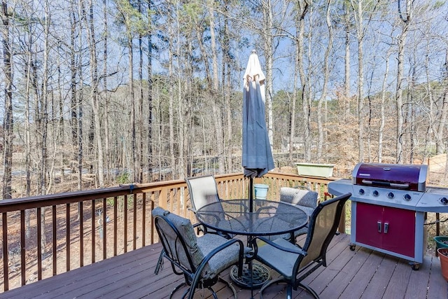 wooden deck with a grill and outdoor dining space