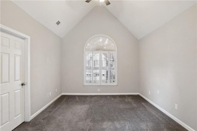 spare room featuring ceiling fan, dark carpet, lofted ceiling, and baseboards