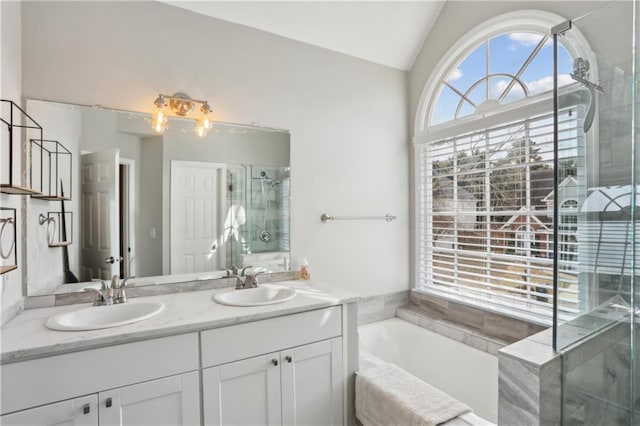bathroom with a stall shower, lofted ceiling, a bath, and double vanity