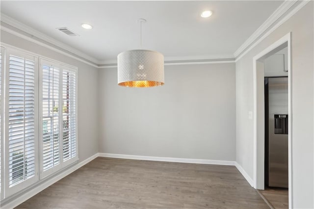 unfurnished dining area featuring crown molding, wood finished floors, baseboards, and recessed lighting