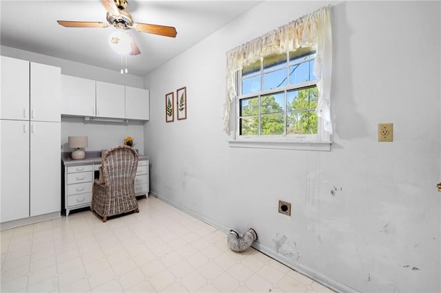 laundry room featuring electric dryer hookup, a ceiling fan, light floors, and cabinet space