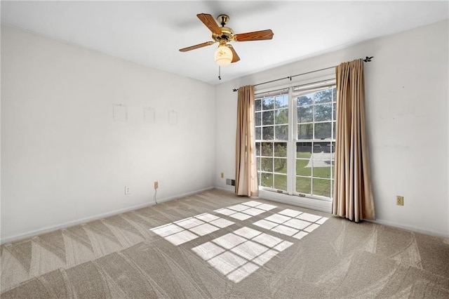 empty room with baseboards, a ceiling fan, and carpet