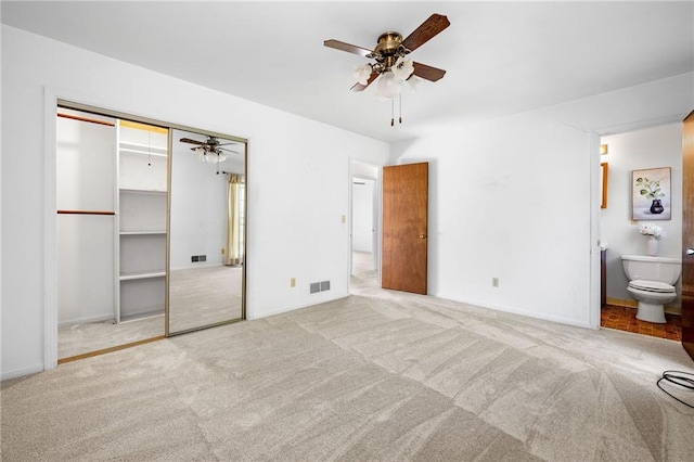 unfurnished bedroom featuring visible vents, a ceiling fan, carpet flooring, and connected bathroom