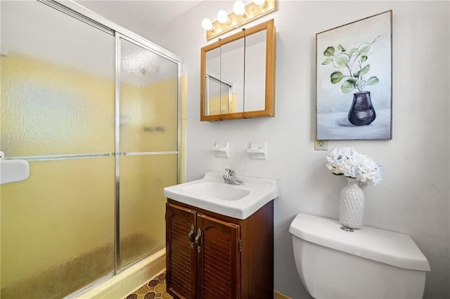 bathroom with toilet, a shower stall, and vanity