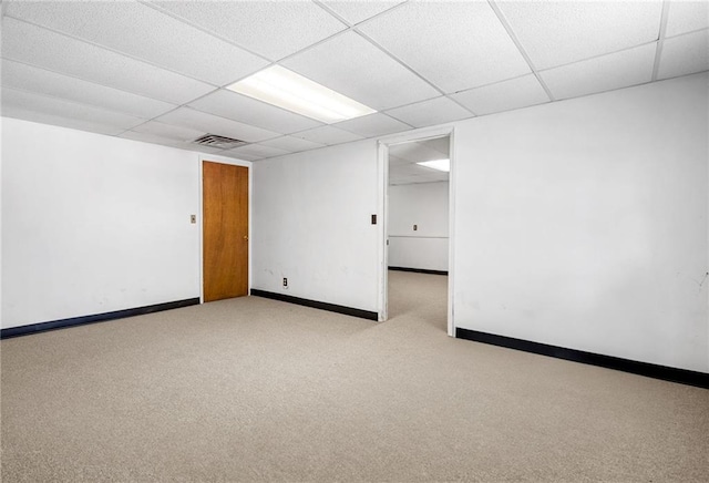 spare room with carpet flooring, visible vents, baseboards, and a paneled ceiling