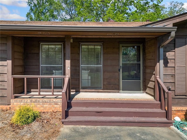 property entrance with roof with shingles and covered porch