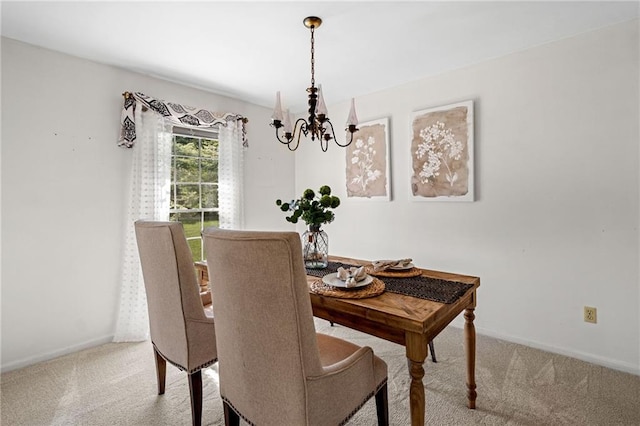 dining area with light carpet, an inviting chandelier, and baseboards