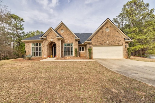 view of front facade with an attached garage, a front lawn, concrete driveway, and brick siding