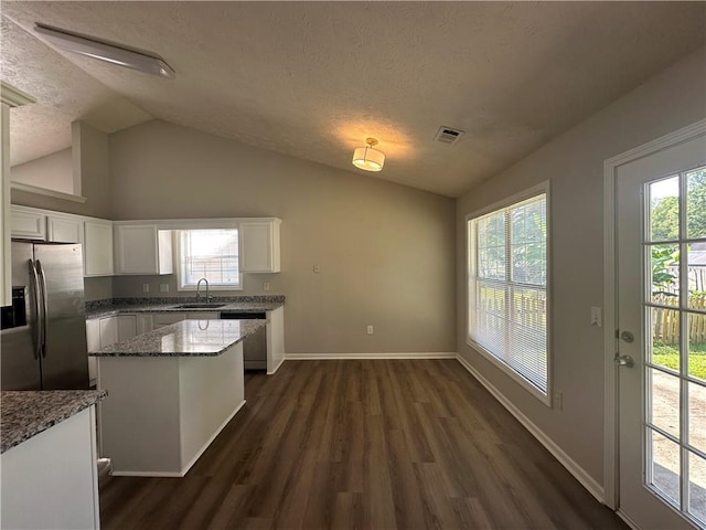 3718 Jackson Bluff Dr, Lawrenceville, GA 30044 - kitchen with stainless steel appliances, vaulted ceiling, white cabinets, dark wood finished floors, and a textured ceiling