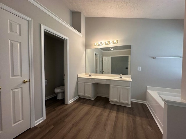 3718 Jackson Bluff Dr, Lawrenceville, GA 30044 - bathroom with double vanity, a bath, wood finished floors, lofted ceiling, and a textured ceiling