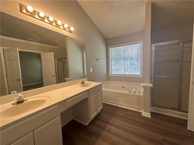3718 Jackson Bluff Dr, Lawrenceville, GA 30044 - bathroom with lofted ceiling, wood finished floors, a textured ceiling, a bath, and double vanity