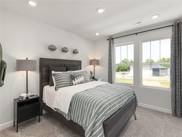 bedroom with recessed lighting, visible vents, light colored carpet, and baseboards