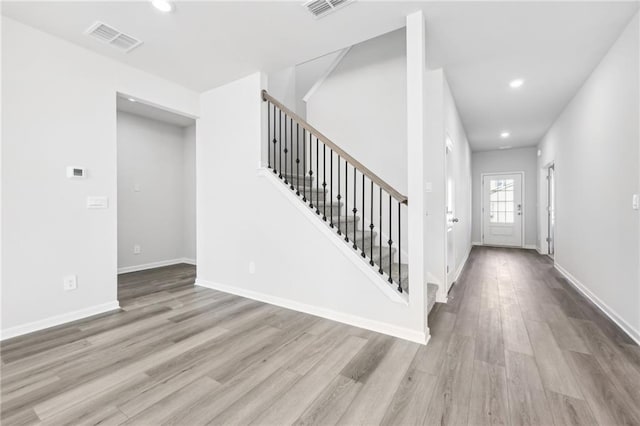 foyer featuring recessed lighting, visible vents, stairway, and wood finished floors