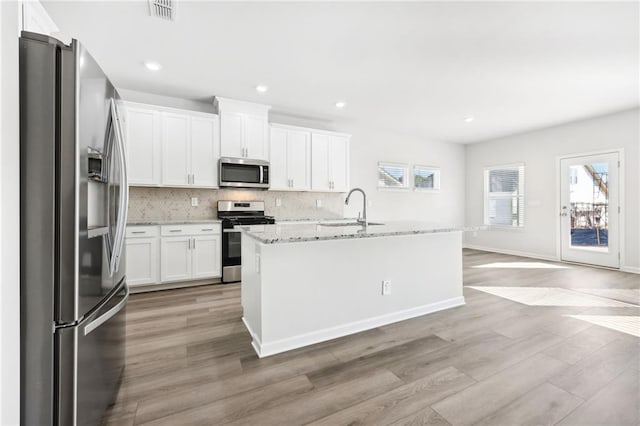 kitchen with visible vents, light wood-style floors, appliances with stainless steel finishes, and a sink