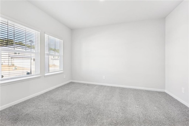 carpeted empty room featuring baseboards