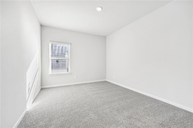 carpeted spare room featuring baseboards and recessed lighting