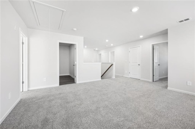 unfurnished living room featuring visible vents, baseboards, attic access, recessed lighting, and carpet