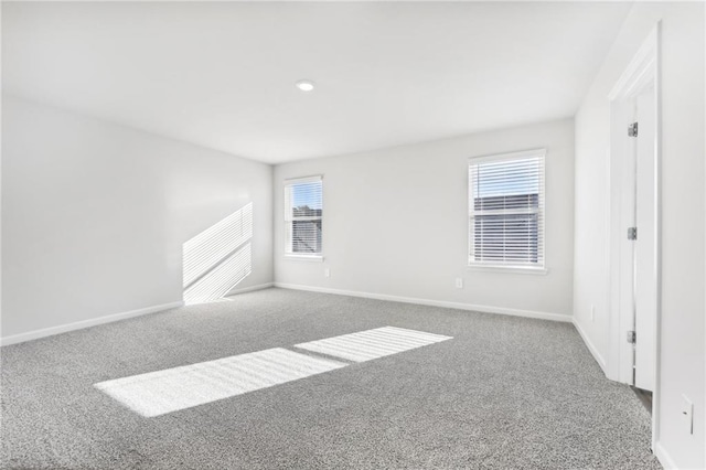 unfurnished bedroom featuring multiple windows, carpet floors, and baseboards