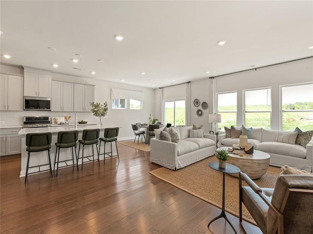 living room with baseboards, recessed lighting, and dark wood-style flooring