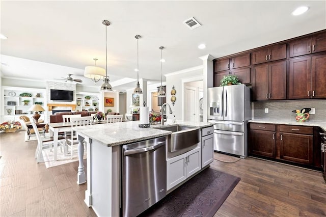 kitchen with visible vents, a ceiling fan, a sink, open floor plan, and appliances with stainless steel finishes