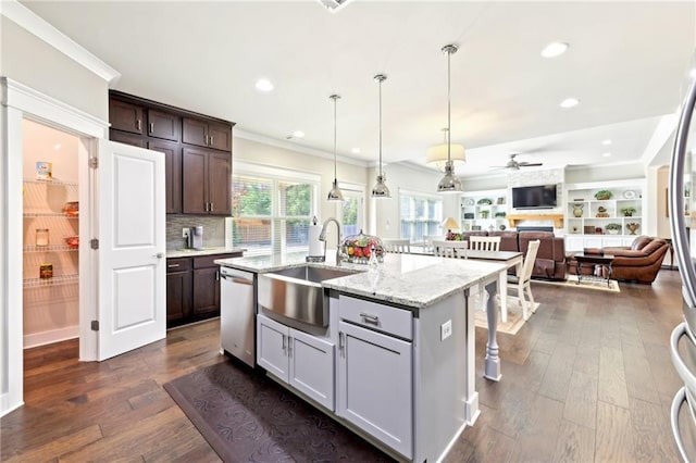 kitchen featuring ornamental molding, a sink, dark wood-type flooring, stainless steel dishwasher, and open floor plan