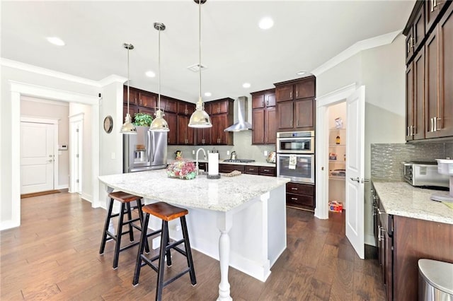 kitchen with a kitchen island with sink, wall chimney exhaust hood, dark wood-type flooring, and ornamental molding